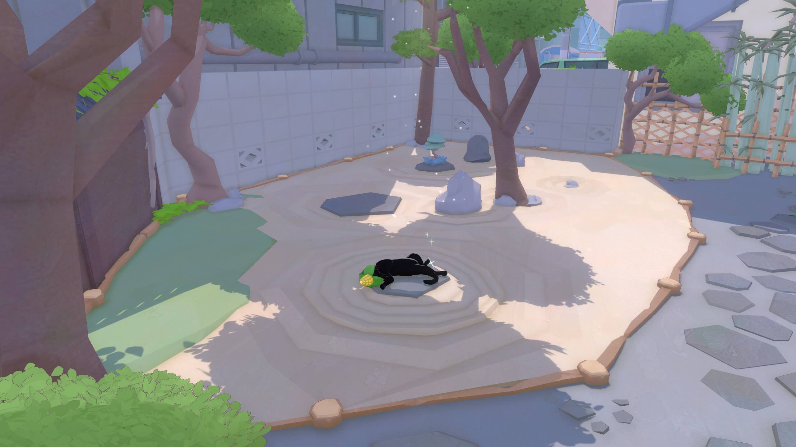 The kitty is taking a nap on a stepping stone in the middle of a sandpit in a garden. In the sandpit there are other stepping stones, rocks and trees.