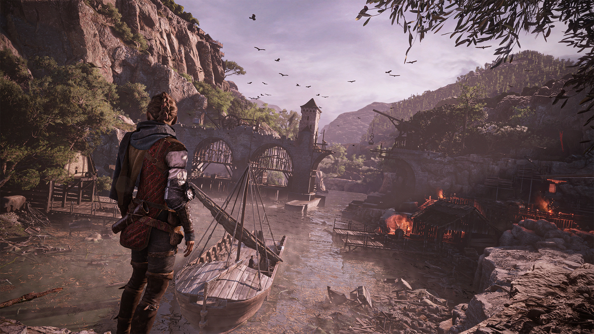 Amicia de Rune from A Plague Tale: Requiem overlooking a river with wooden structures on the right riverbank on fire